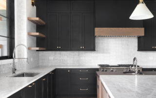 A black kitchen with stainless steel appliances, preventing paint wear on cabinets